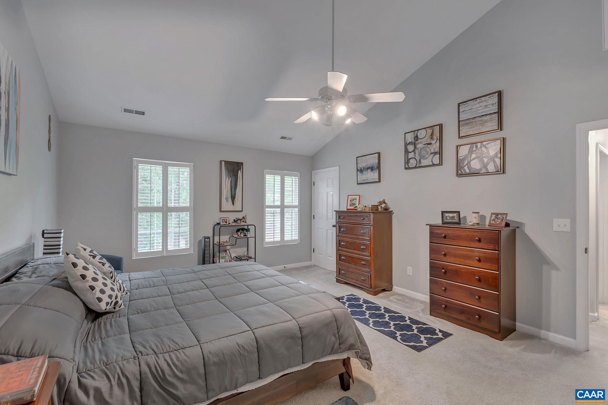 57 Amethyst Road Palmyra, VA 22963 - Photo 17 of 36 a bedroom with a large bed and a chandelier