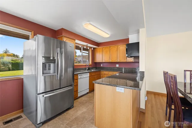 a kitchen with stainless steel appliances granite countertop a stove and a microwave