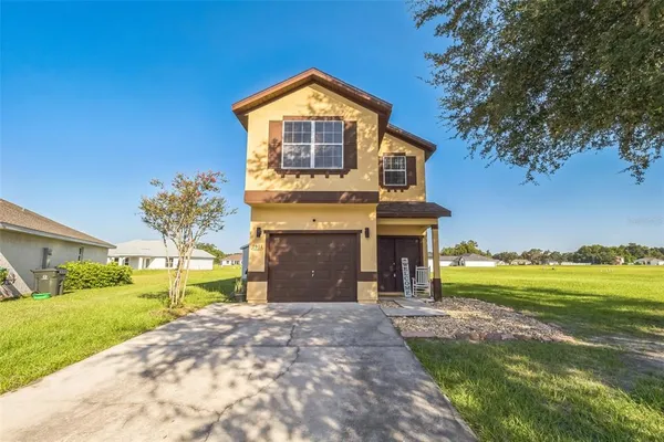 a front view of a house with a yard and garage