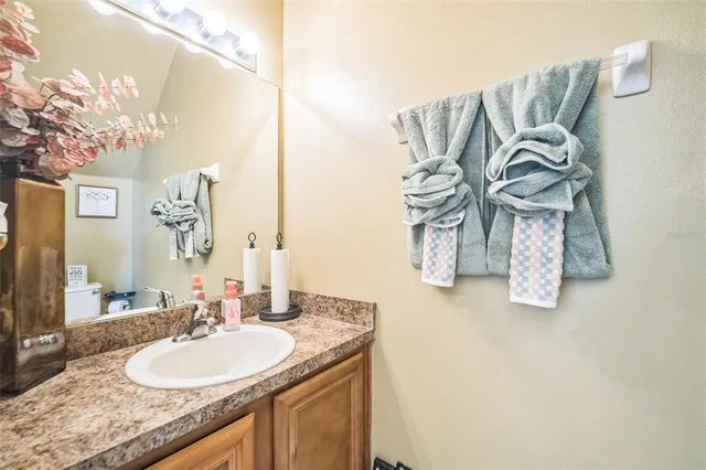 a bathroom with a granite countertop sink and a mirror