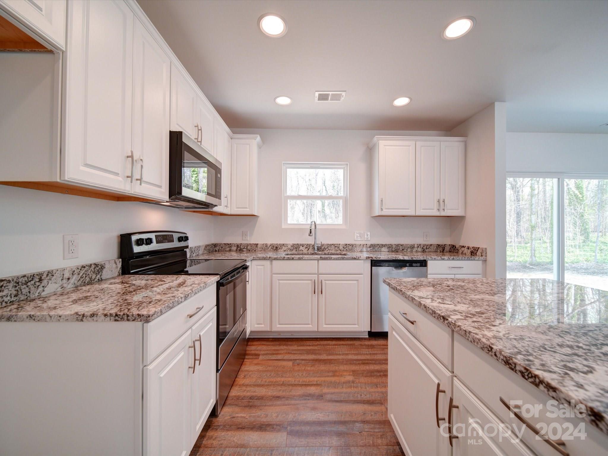 147 Lambeth Road Thomasville, NC 27360 - Photo 12 of 33 a kitchen with stainless steel appliances granite countertop a stove sink and cabinets
