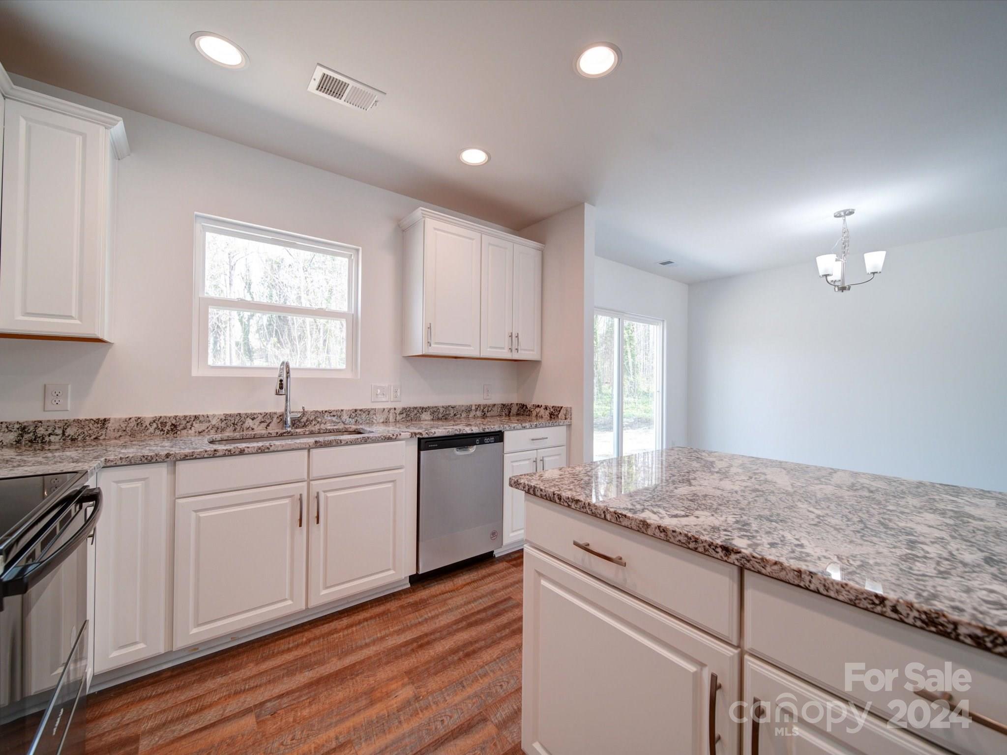 147 Lambeth Road Thomasville, NC 27360 - Photo 13 of 33 a kitchen with granite countertop cabinets stainless steel appliances a sink and a window