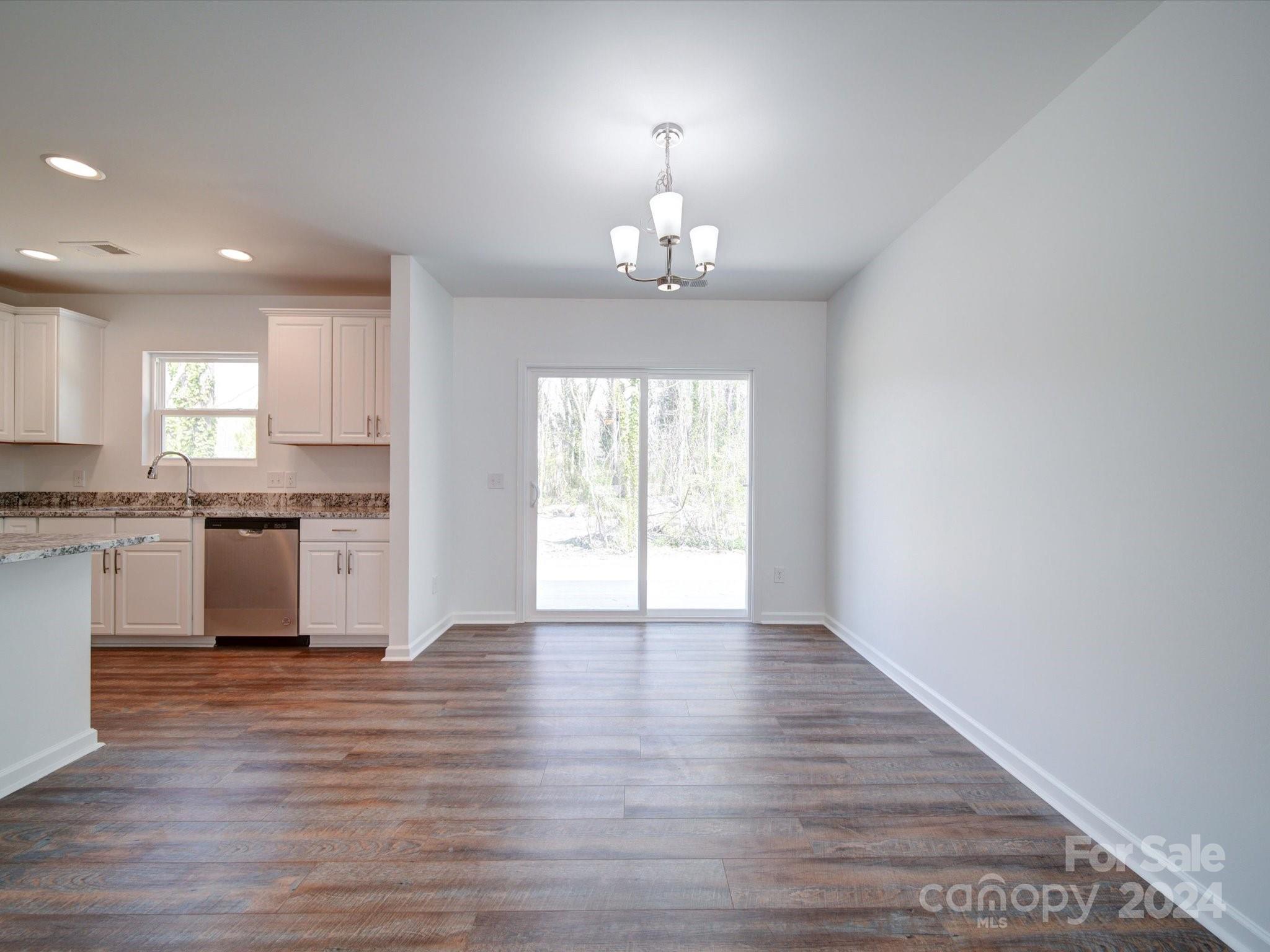 147 Lambeth Road Thomasville, NC 27360 - Photo 7 of 33 a view of an empty room with kitchen and wooden floor
