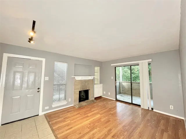 an empty room with fireplace and windows