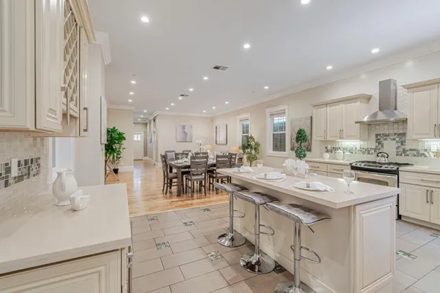 a kitchen with stainless steel appliances granite countertop a table and chairs in it