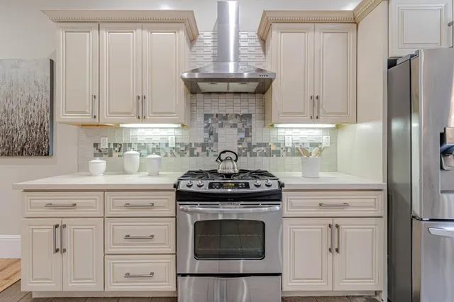 a stove top oven sitting inside of a kitchen