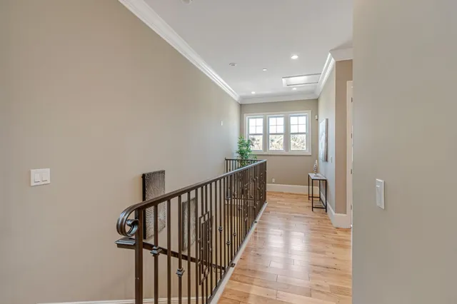 a view of a hallway with wooden floor and windows