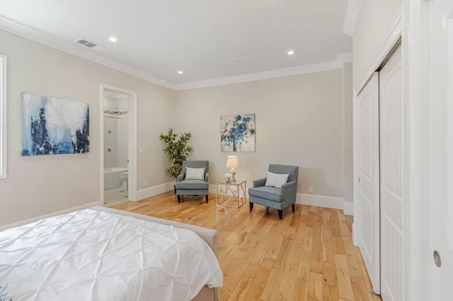 a bedroom with a bed and wooden floor