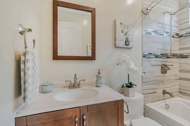 a bathroom with a sink vanity toilet and shower