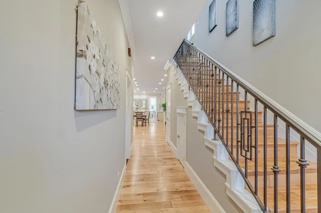 a view of a hallway with wooden floor and stairs
