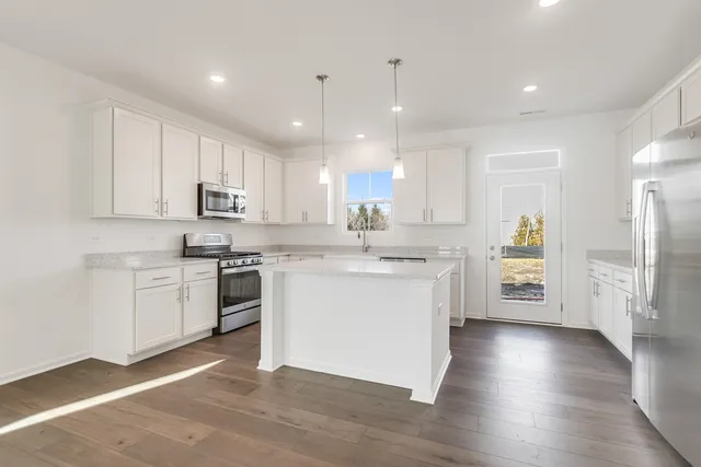a kitchen with a refrigerator sink and cabinets