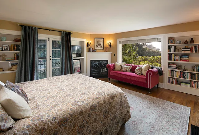 a spacious bedroom with a bed a couch and a window