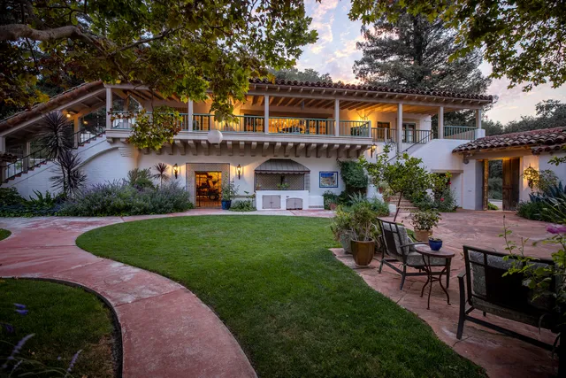 a front view of a house with a garden and plants
