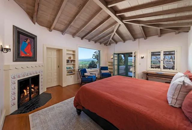 a spacious bedroom with a large bed and a fireplace