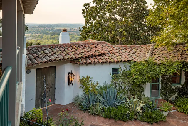 a front view of a house with a garden and plants