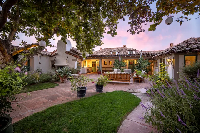 a living room with furniture a fireplace and a floor to ceiling window