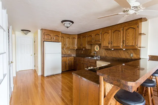 a kitchen with kitchen island a counter top space a sink a refrigerator and cabinets