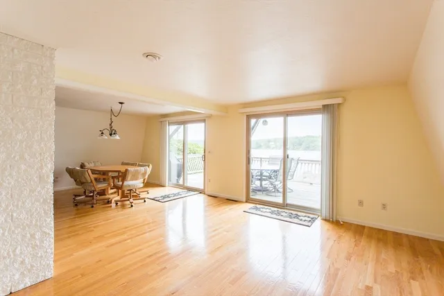 a living room with dining table and a chandelier
