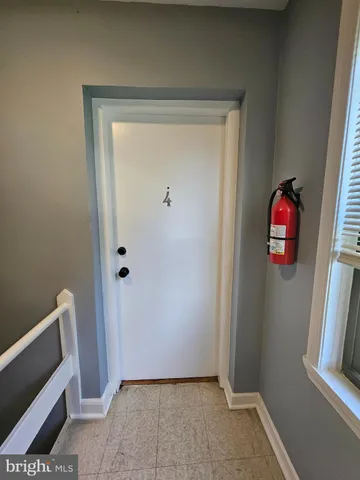 a view of an empty room with wooden floor and window