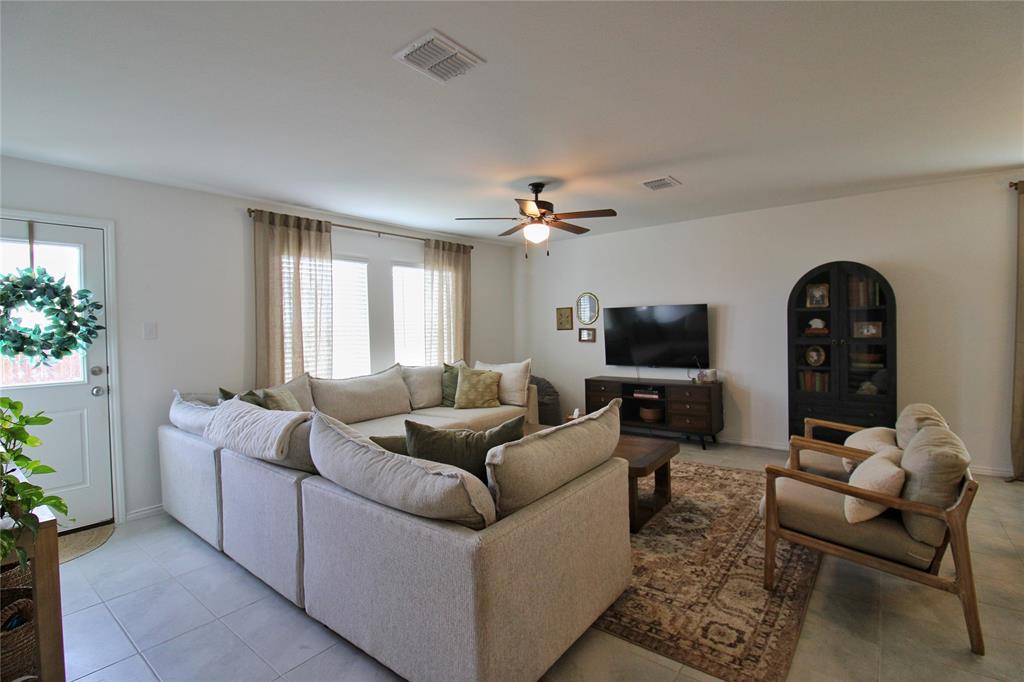 11740 Marcellus Way Rhome, TX 76078 - Photo 12 of 33 a living room with furniture a lamp and a window