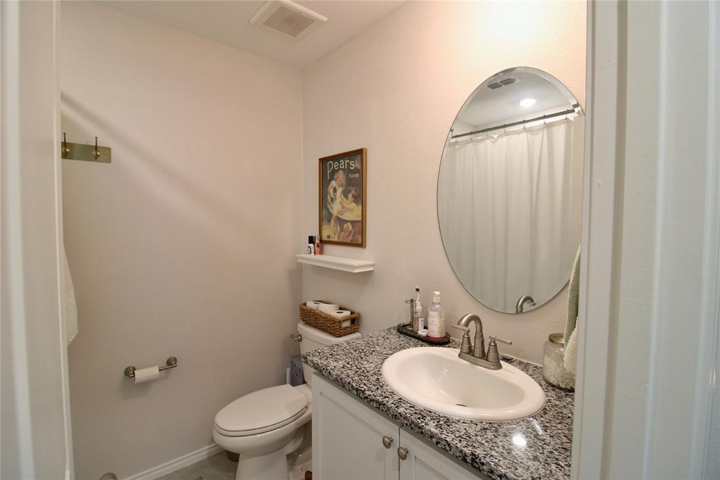 11740 Marcellus Way Rhome, TX 76078 - Photo 15 of 33 a bathroom with a granite countertop sink toilet and a mirror
