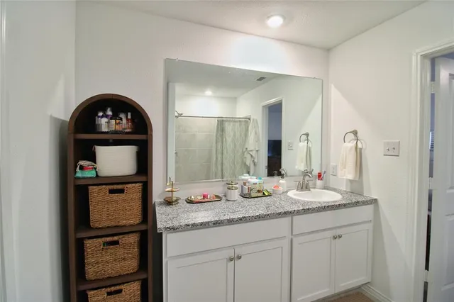 a bathroom with a granite countertop sink and a mirror