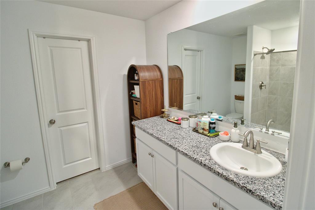 11740 Marcellus Way Rhome, TX 76078 - Photo 24 of 33 a bathroom with a granite countertop sink and a mirror
