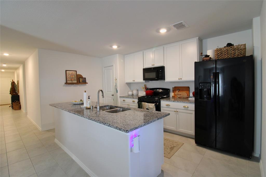 11740 Marcellus Way Rhome, TX 76078 - Photo 27 of 33 a kitchen with stainless steel appliances granite countertop a sink a stove and a refrigerator