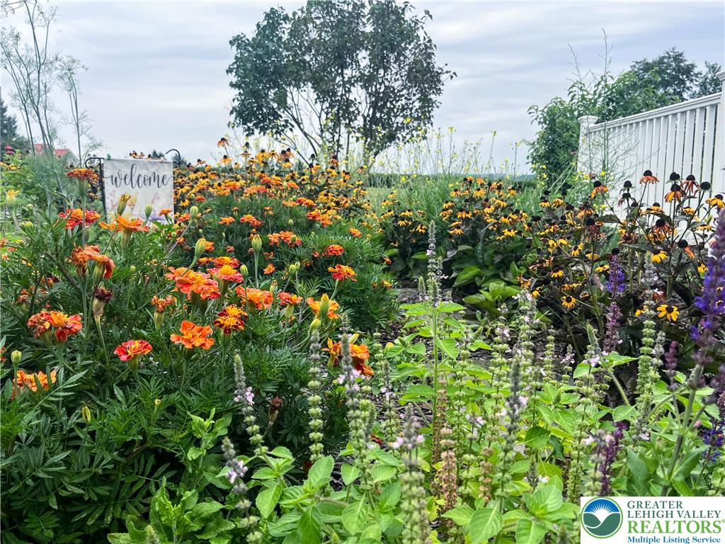 3285 Cherryville Road Northampton, PA 18067 - Photo 50 of 51 Lush plantings and vibrant garden beds frame a classic white boundary fence.