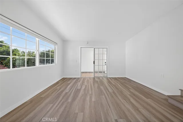 a view of a room with wooden floor and white walls