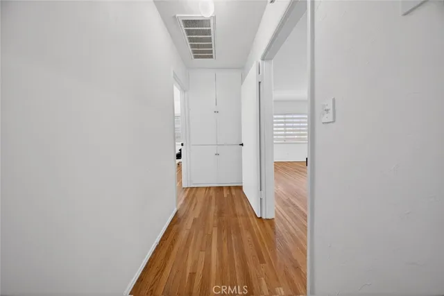 a view of empty room with wooden floor