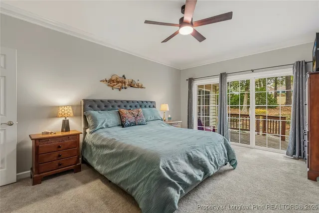 a bedroom with a large bed and a chandelier fan