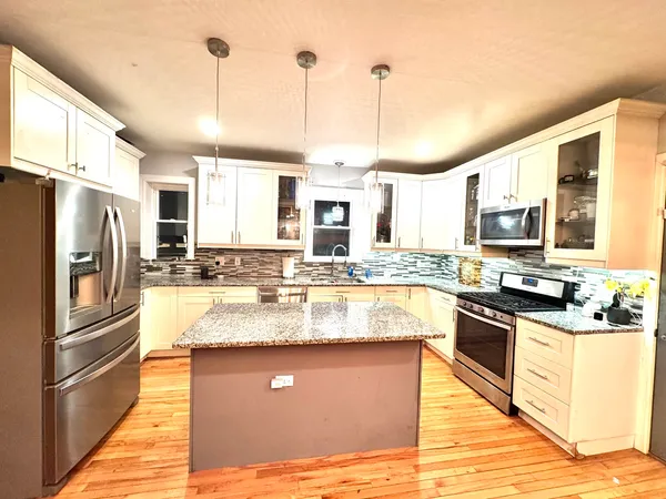 a kitchen with stainless steel appliances granite countertop a sink a stove and refrigerator