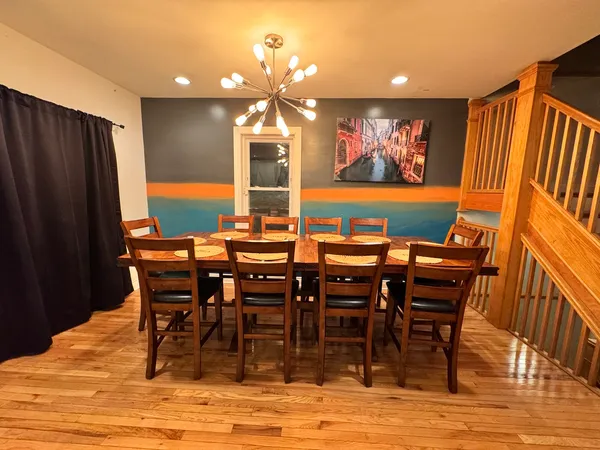 a view of a dining room with furniture a chandelier and wooden floor