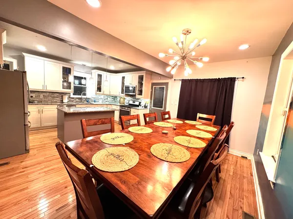 a dining room with furniture a chandelier and wooden floor