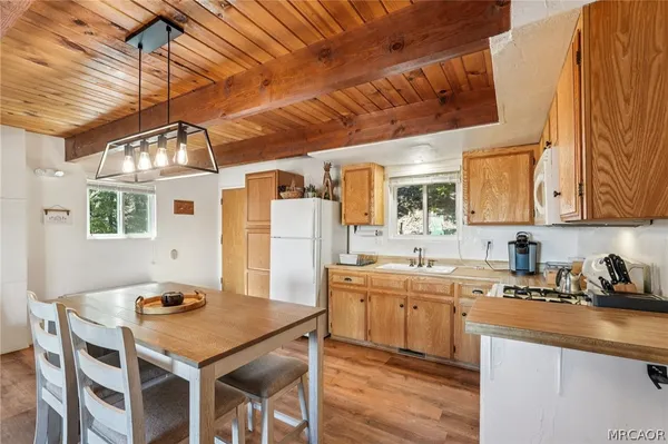 a kitchen with stainless steel appliances granite countertop a sink a stove and chairs