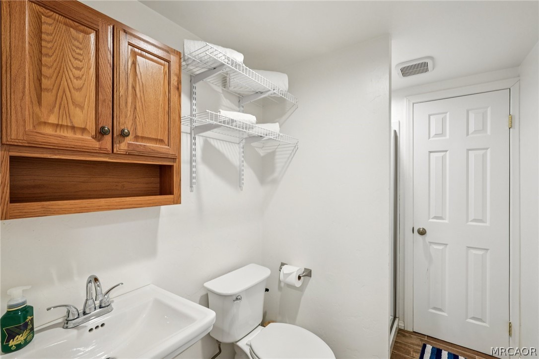 2409 Spring Oak Drive Running Springs, CA 92382 - Photo 19 of 24 a bathroom with a sink a toilet and tub