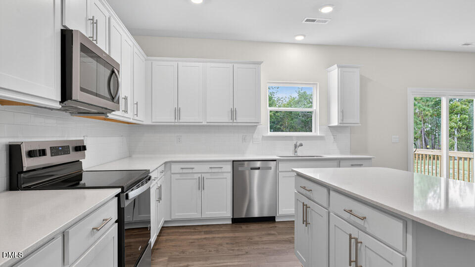 189 Calebs Cor Place Spring Lake, NC 28390 - Photo 16 of 42 a kitchen with white cabinets appliances a sink and a window