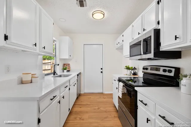 a kitchen with cabinets appliances and a sink