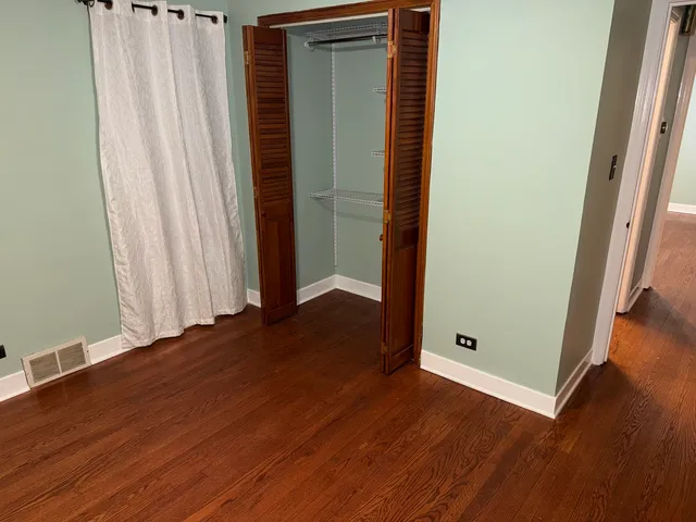 an empty room with wooden floor and closet