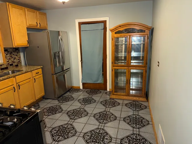 a kitchen with a refrigerator and cabinets