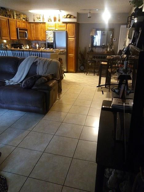 a living room with patio furniture and a kitchen view