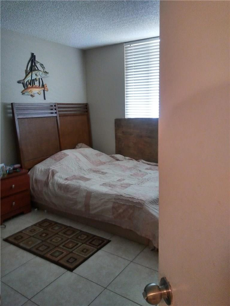 621 Lyons Road, Unit 9101 Coconut Creek, FL 33063 - Photo 3 of 21 a bedroom with a bed and window
