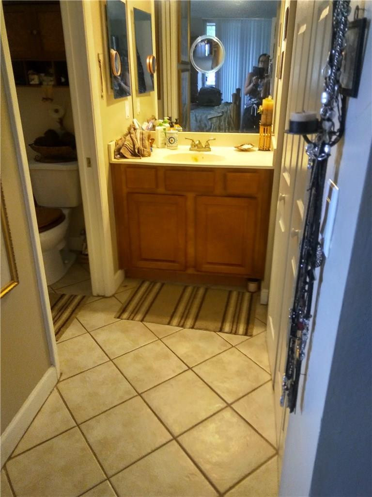 621 Lyons Road, Unit 9101 Coconut Creek, FL 33063 - Photo 5 of 21 a bathroom with a sink and a mirror