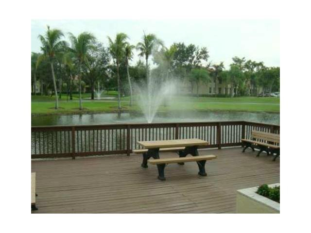 621 Lyons Road, Unit 9101 Coconut Creek, FL 33063 - Photo 8 of 21 a view of a deck with a table and chairs next to a yard