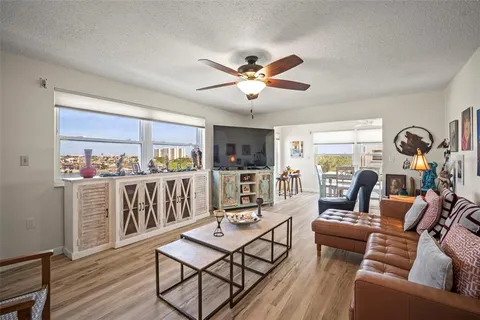 a living room with furniture a ceiling fan and a bookshelf