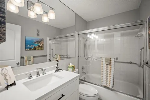 a bathroom with a sink toilet a mirror and shower