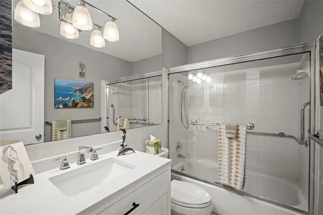 a bathroom with a sink toilet a mirror and shower