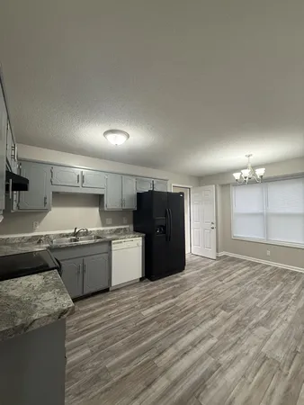 a large kitchen with stainless steel appliances granite countertop a stove and a refrigerator