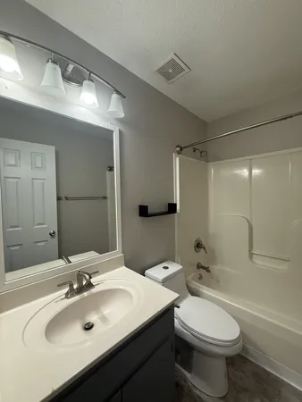 a bathroom with a sink toilet mirror and shower
